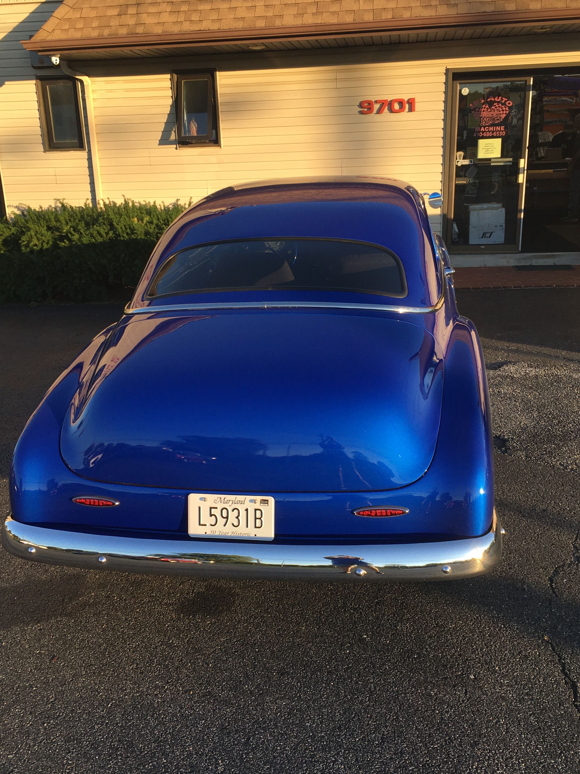Blue classic car parked outside a building with the address 3701.