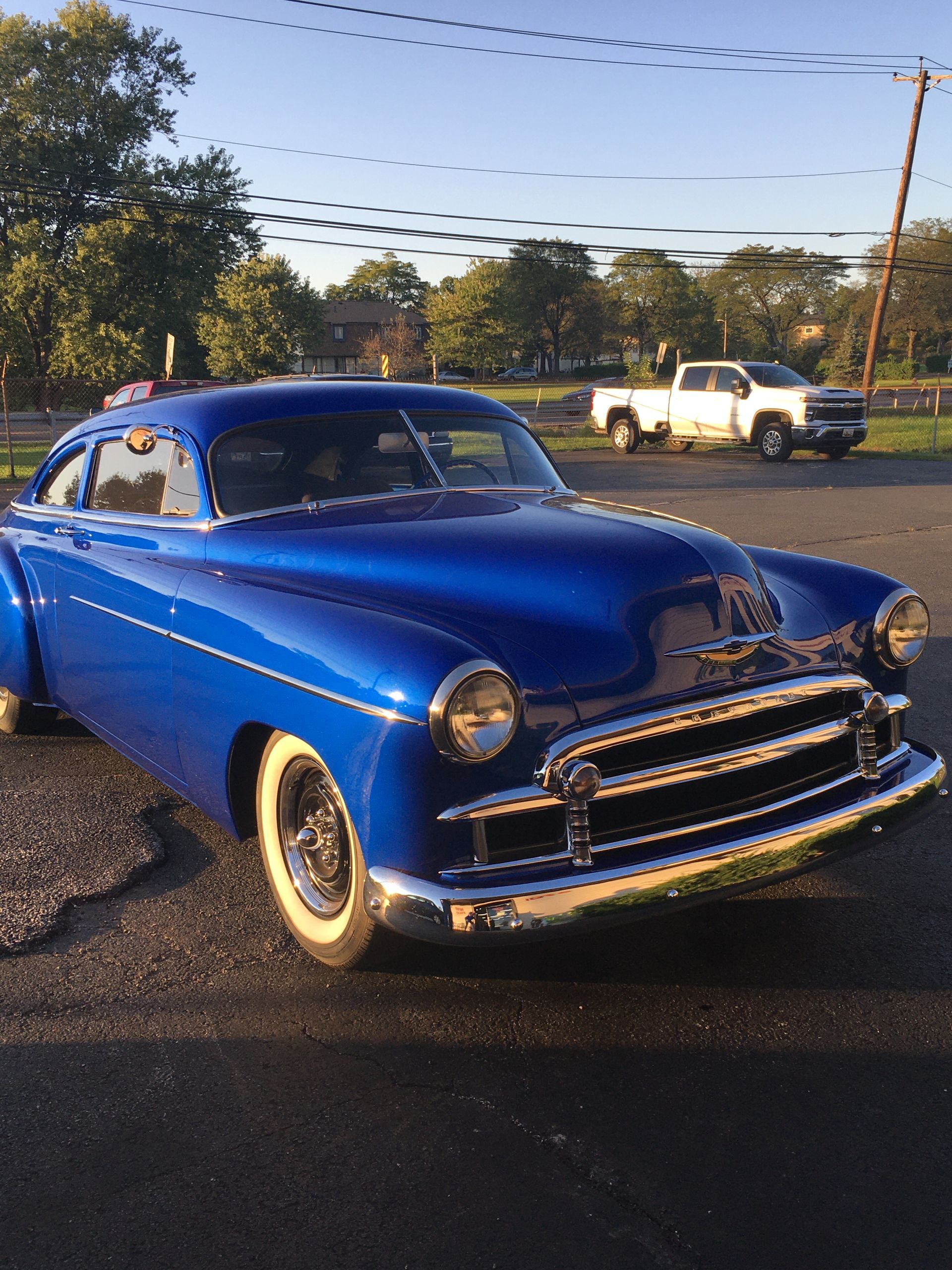 Blue classic Chevrolet car parked outside, sunny day.