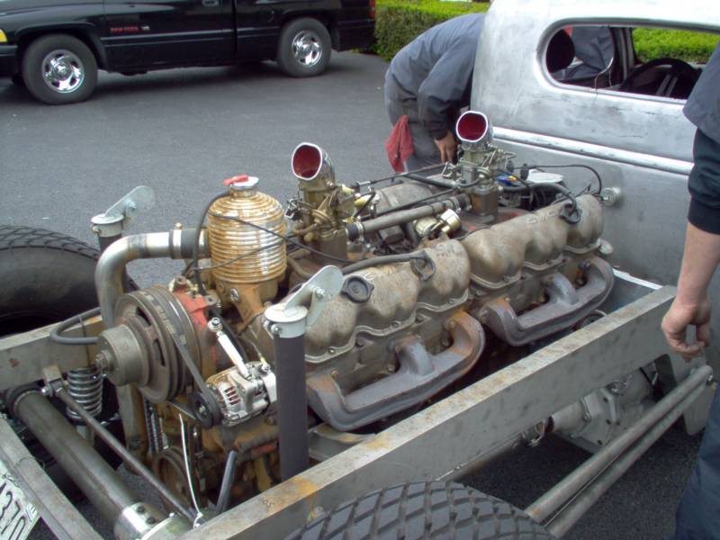 Custom hot rod with a large engine being worked on.