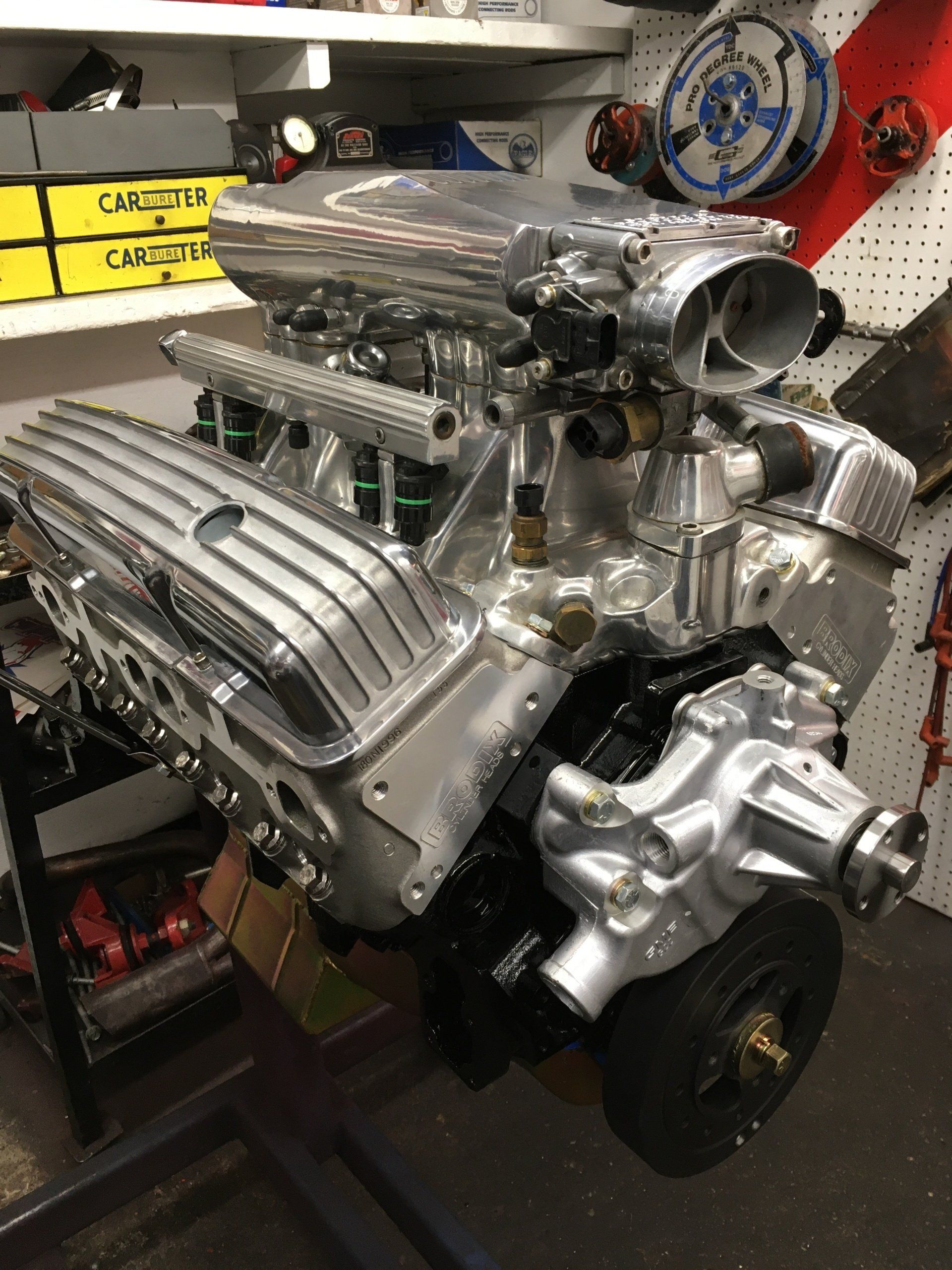 Shiny, rebuilt V8 engine in a workshop, with polished aluminum components, ready for installation.