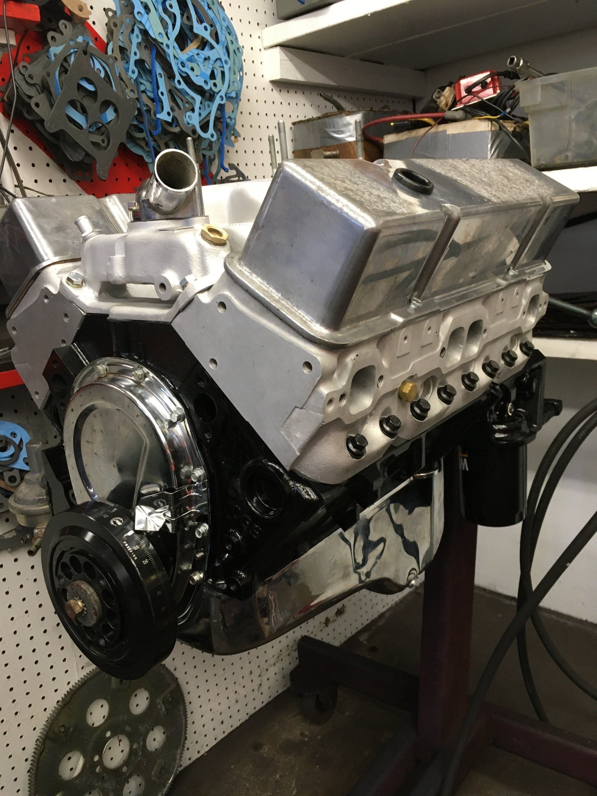 Silver and black engine on a stand in a workshop.