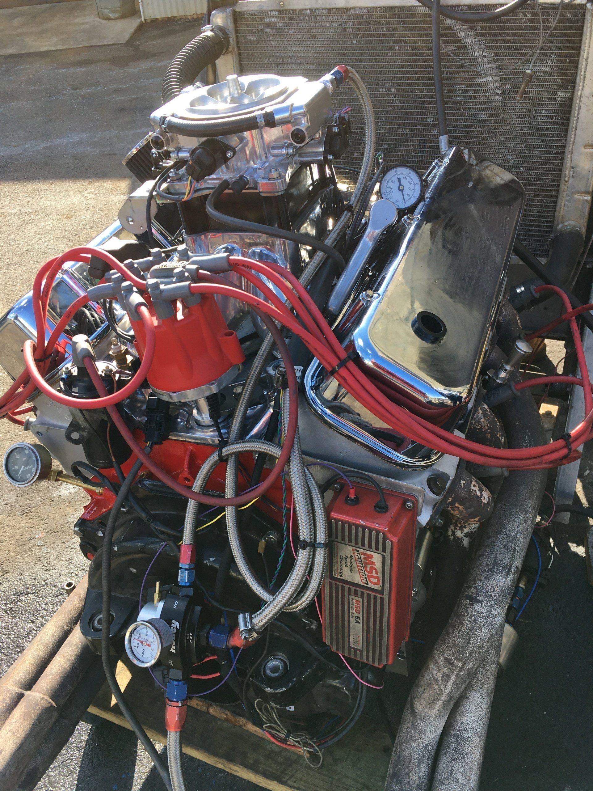 Modified V8 engine with red wires and chrome components.