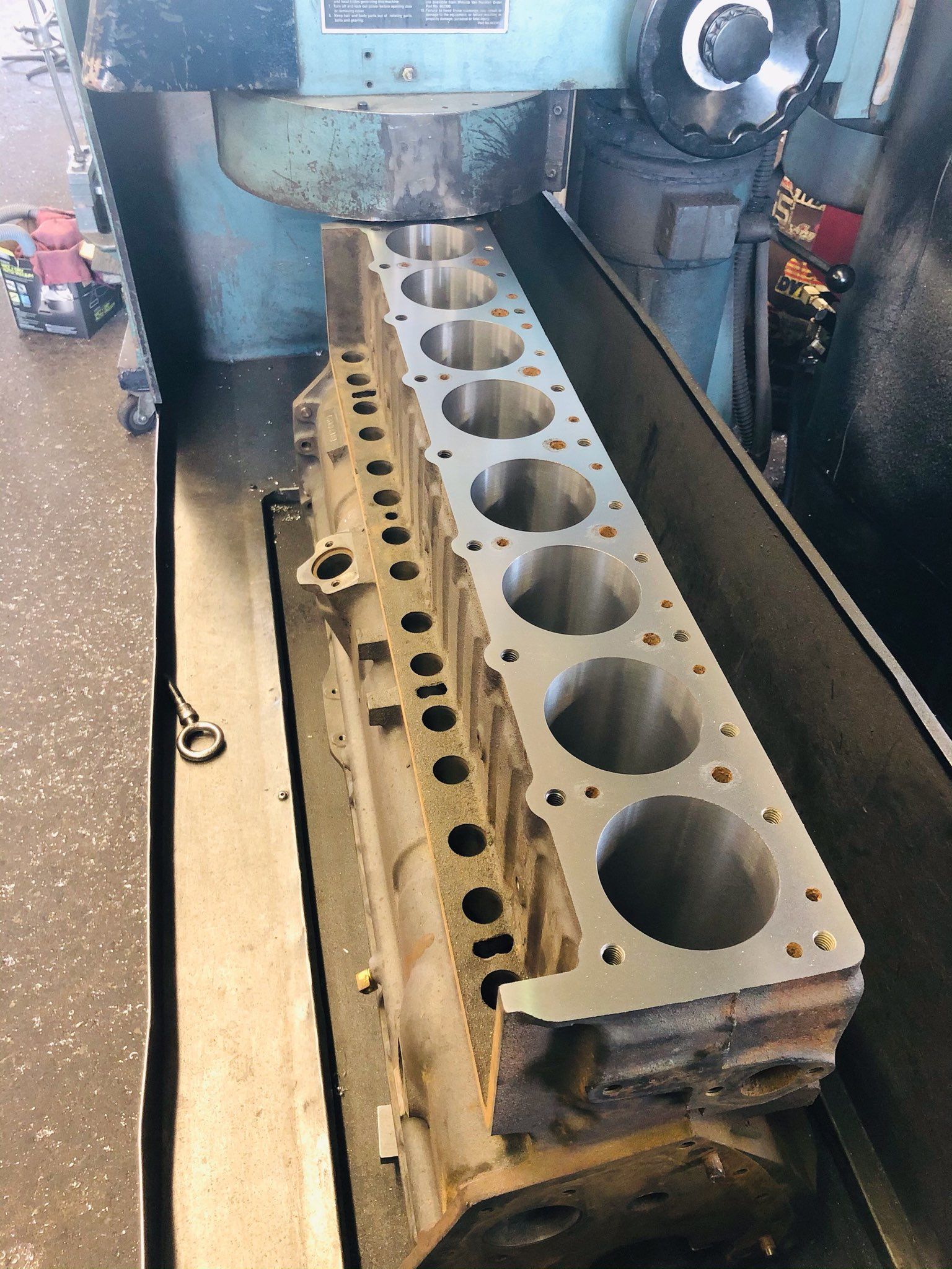Engine block being resurfaced on a machine in a workshop.