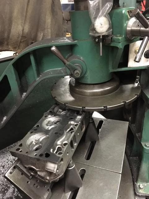 An engine cylinder head being resurfaced on a milling machine in a workshop.
