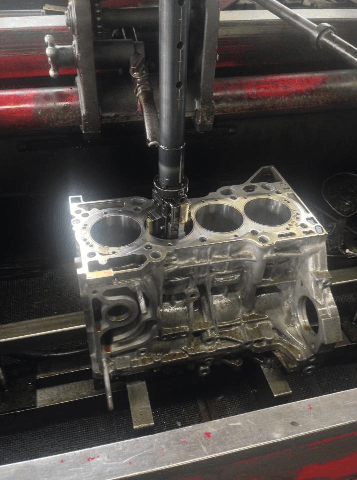 Engine block being machined by a vertical milling machine.