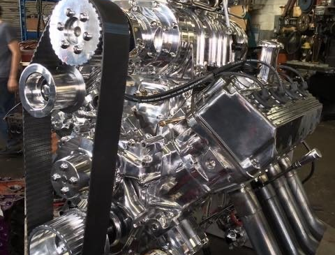 Shiny chrome engine with belt drive and headers.
