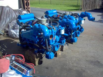 Two bright blue boat engines sitting outside, possibly on blocks.