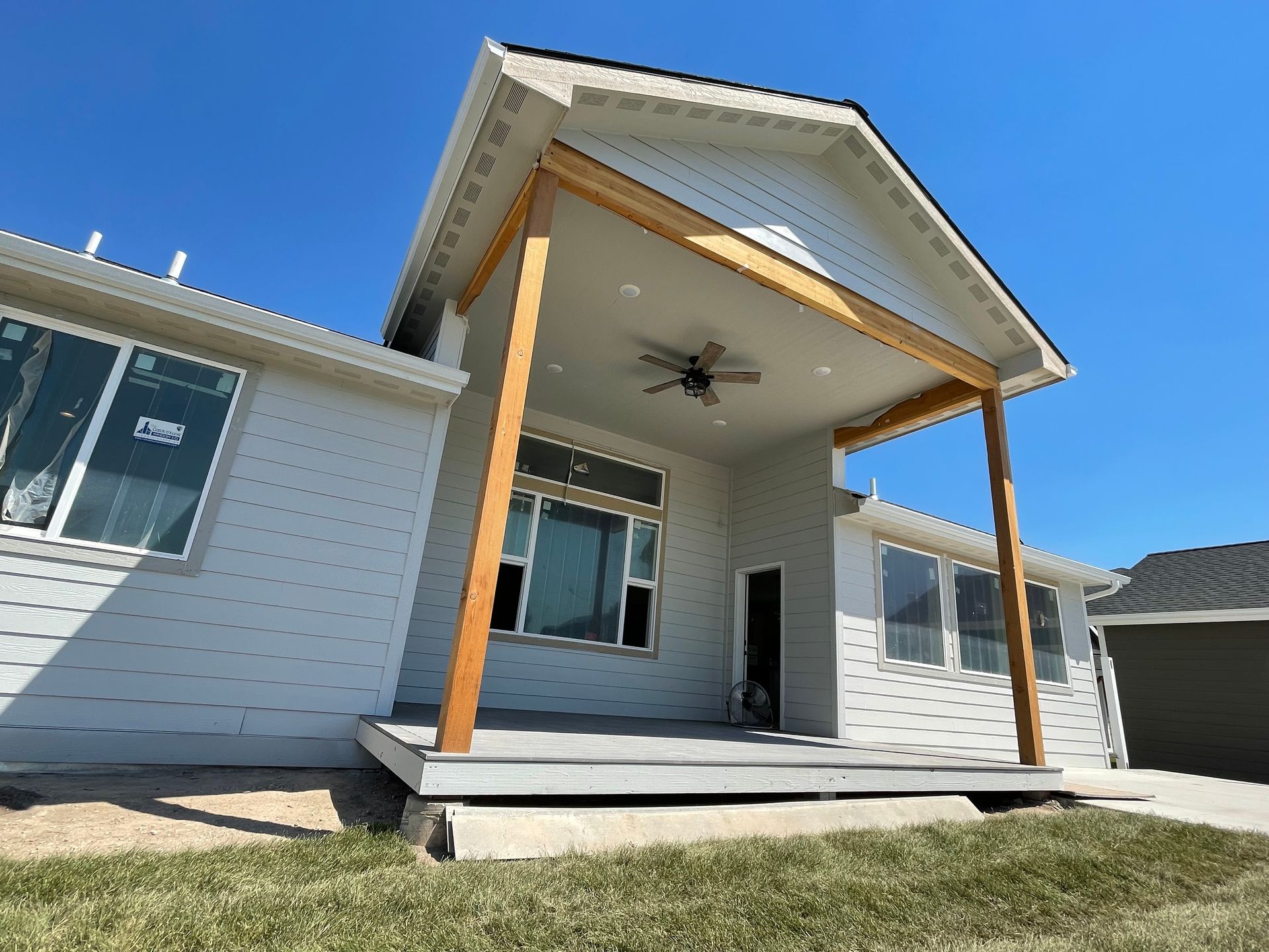 Person using a drill to install wooden deck boards with leveling supports.