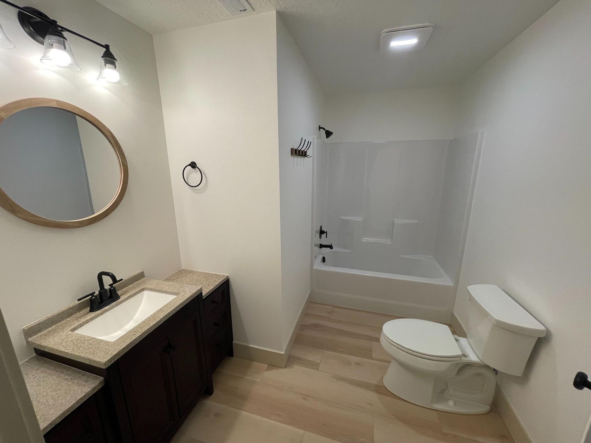 Bathroom with a vanity, toilet, and bathtub/shower.