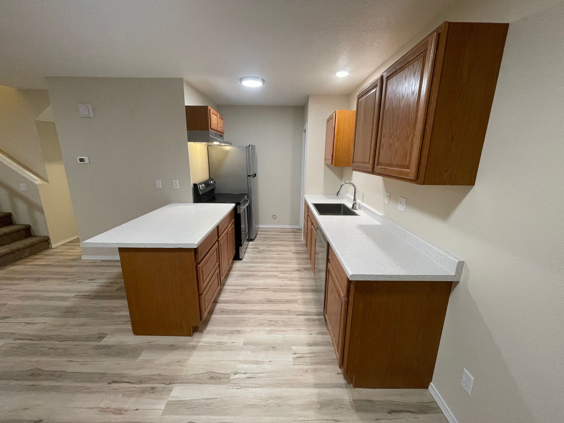 Kitchen with light wood cabinets, white countertops, and stainless steel appliances.