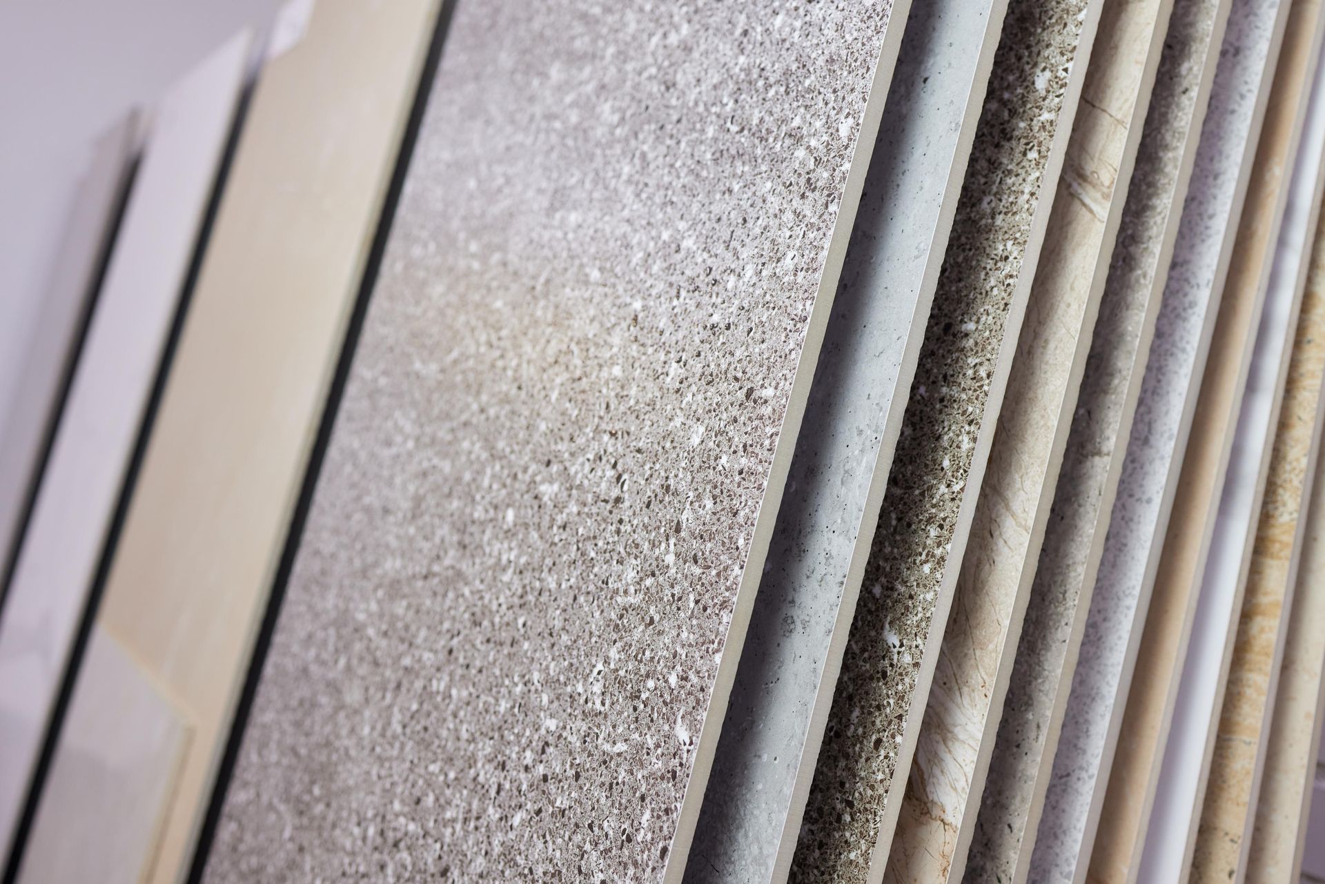 Samples of stone or tile, various textures and colors, arranged vertically.