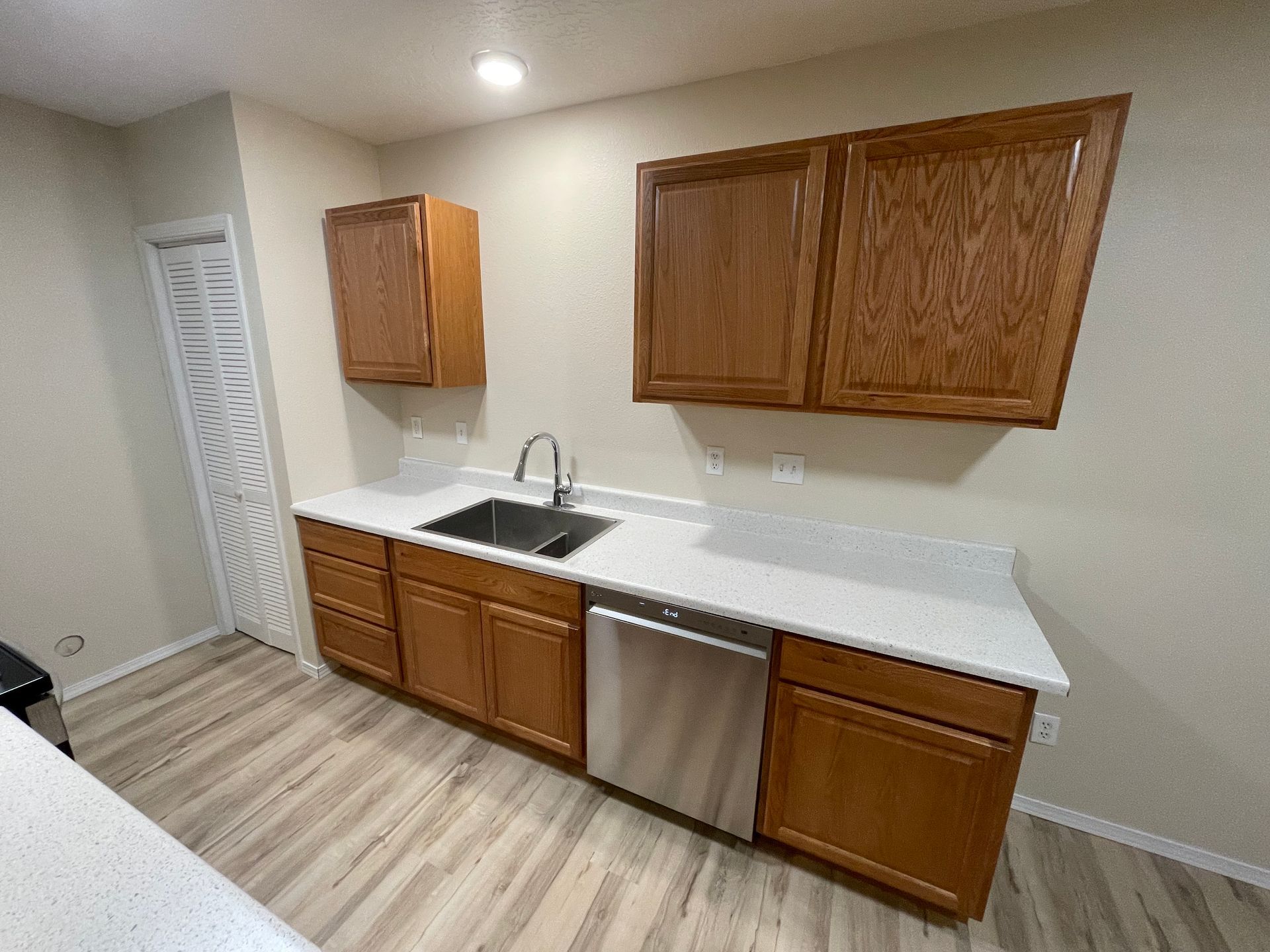 Kitchen with wood cabinets, stainless steel appliances, and white countertops.