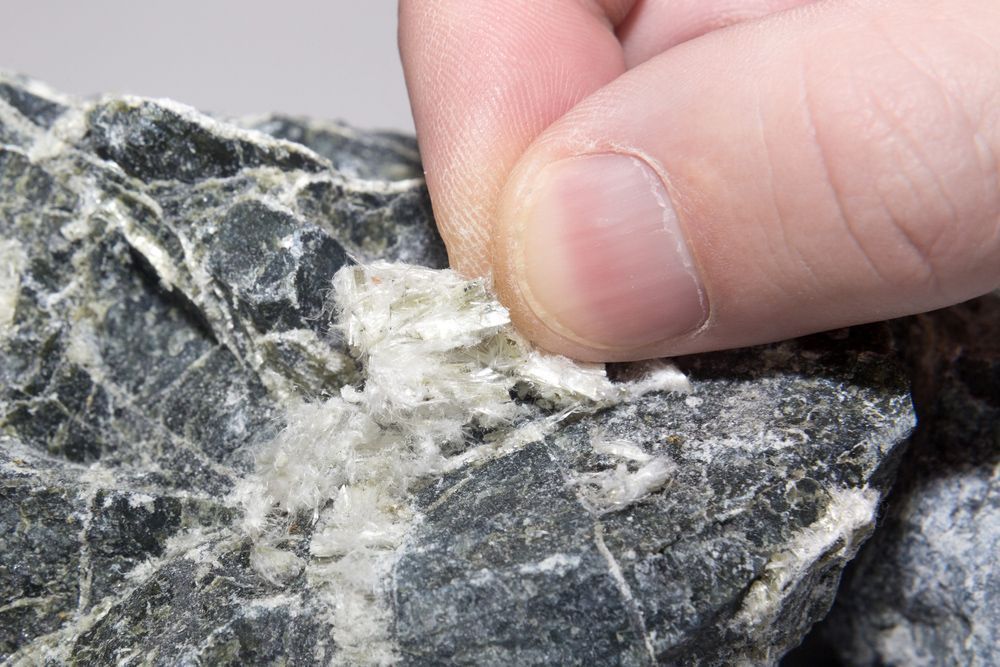 A person is holding a piece of asbestos in their hand.