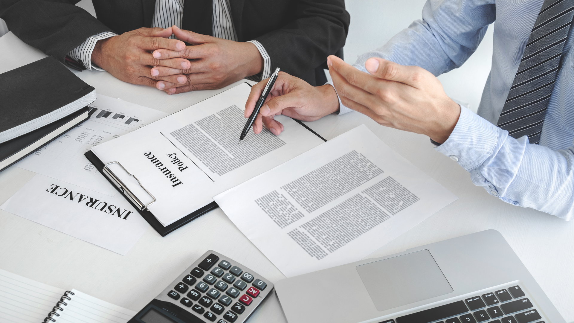 Two men are sitting at a table looking at a piece of paper.