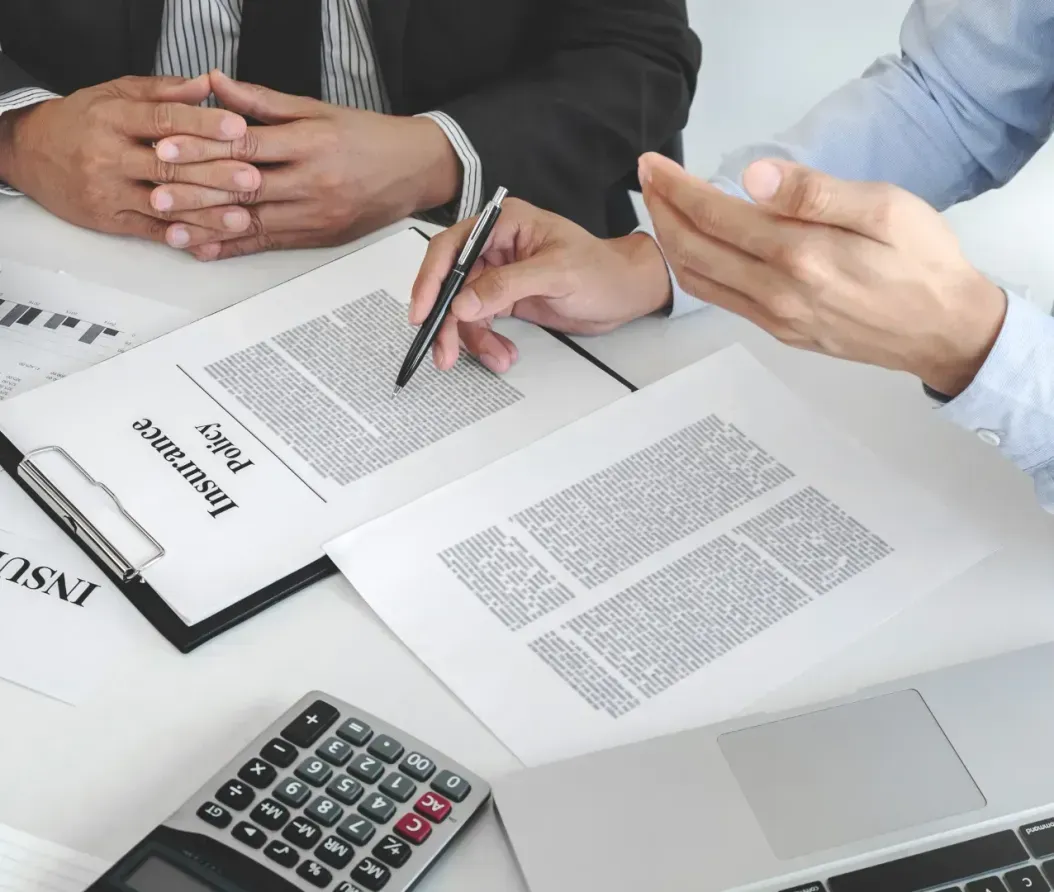 Two men are sitting at a table looking at a piece of paper.