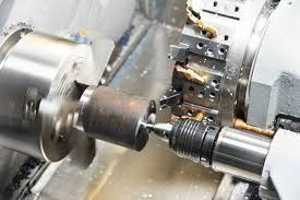 Torno CNC mecanizando una pieza cilíndrica de metal.