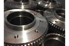 Primer plano de varios engranajes metálicos mecanizados, posiblemente para maquinaria. Acabado brillante, de varios tamaños, con detalles de los dientes.