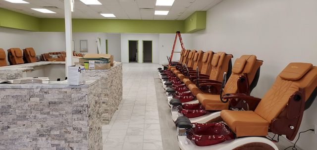A row of chairs are lined up in a nail salon