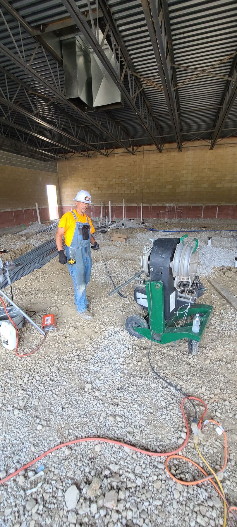 A man is standing in a room with a machine on the floor.