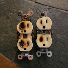 Two electrical outlets are sitting on a tiled floor.