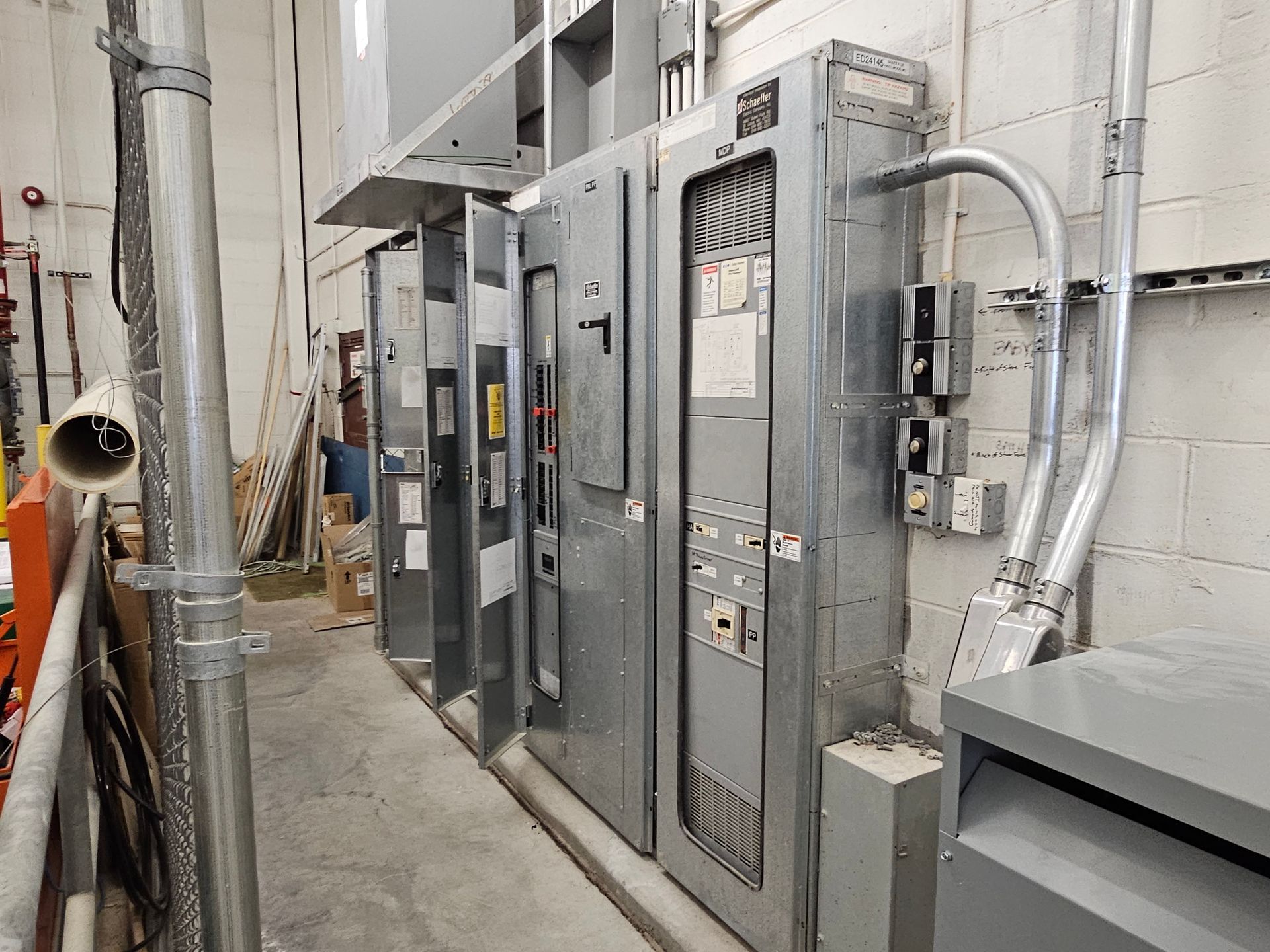 A row of electrical panels are lined up in a room.