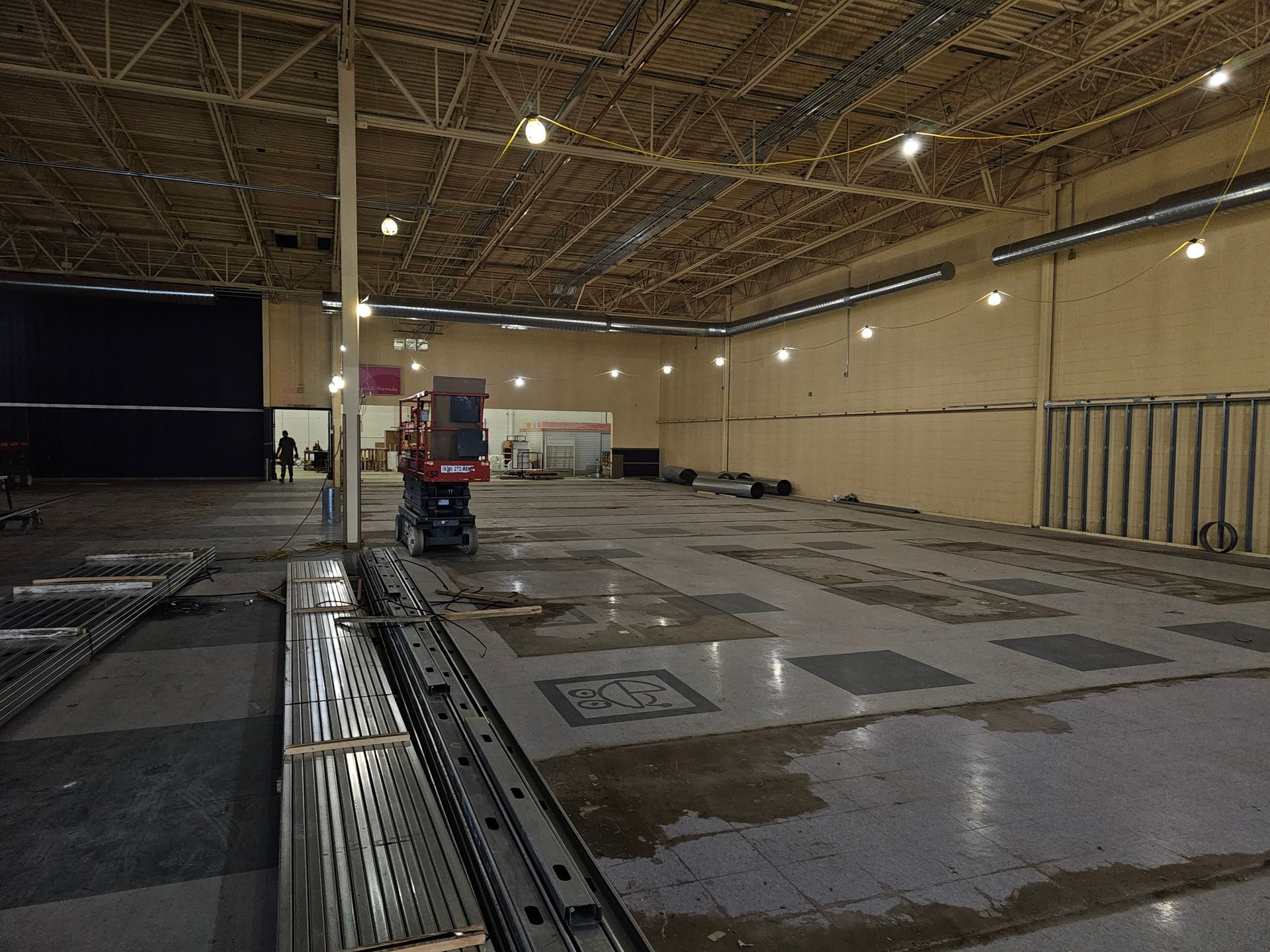A large empty warehouse with a lot of lights on the ceiling.