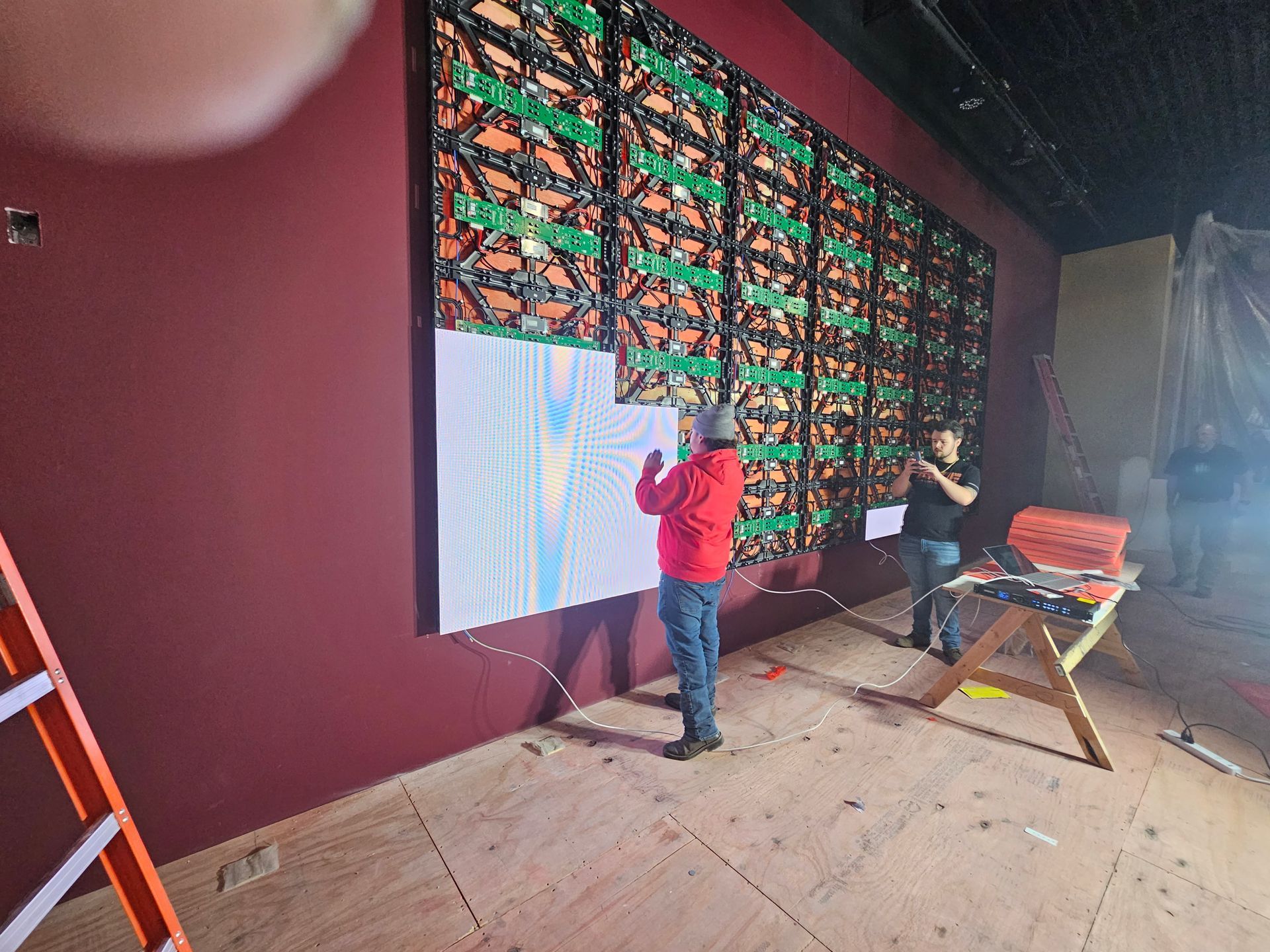 A group of people are working on a large wall.