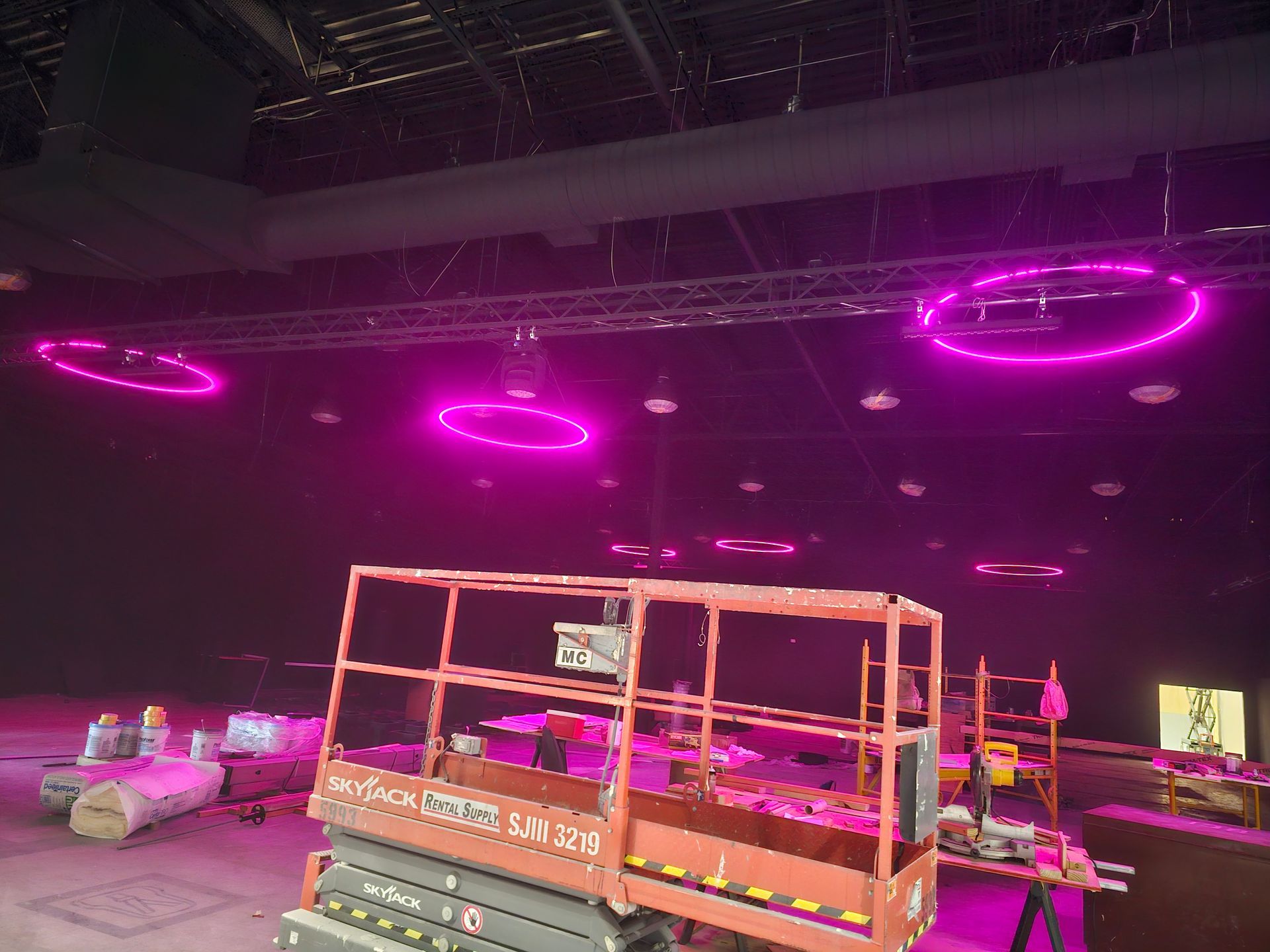 A large room with purple lights hanging from the ceiling.