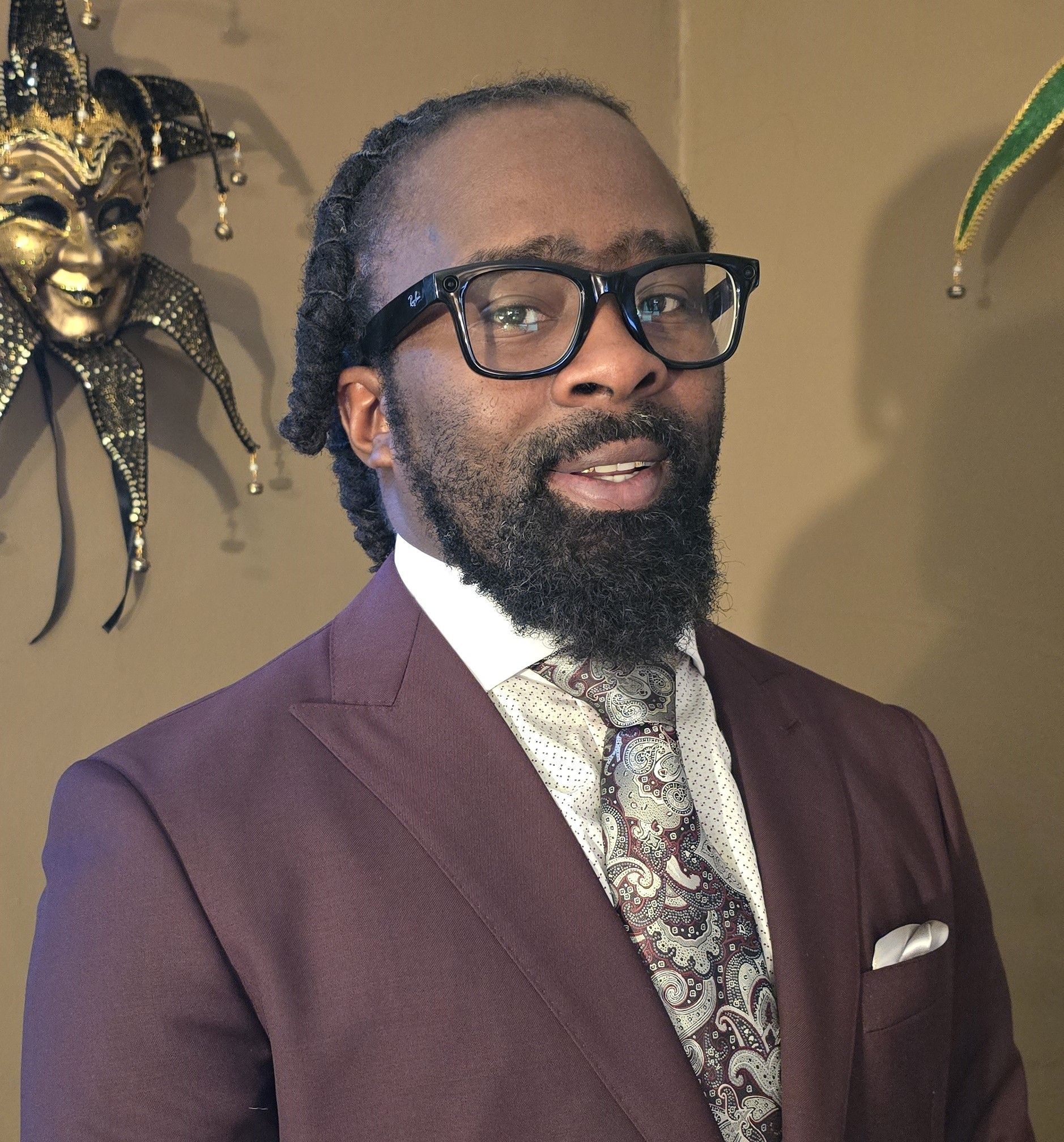 A man with a beard wearing glasses and a suit