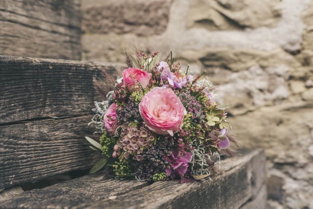 Pink floral arrangement on wooden seat for peaceful graveside service, funeral homes Upper Darby, PA