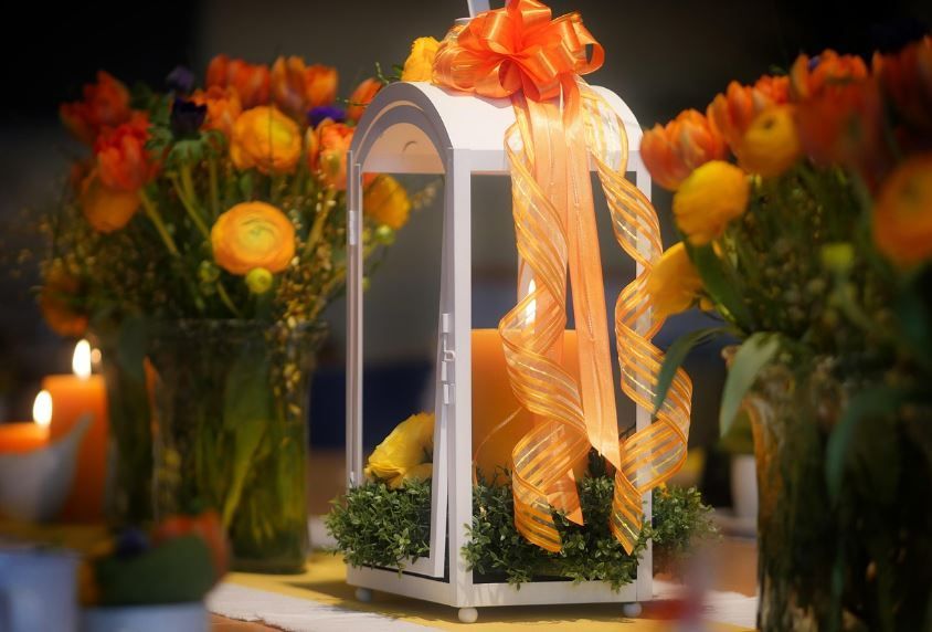 Yellow-orange ranunculus bouquet beside a ribboned lantern, cremation services Downingtown, PA