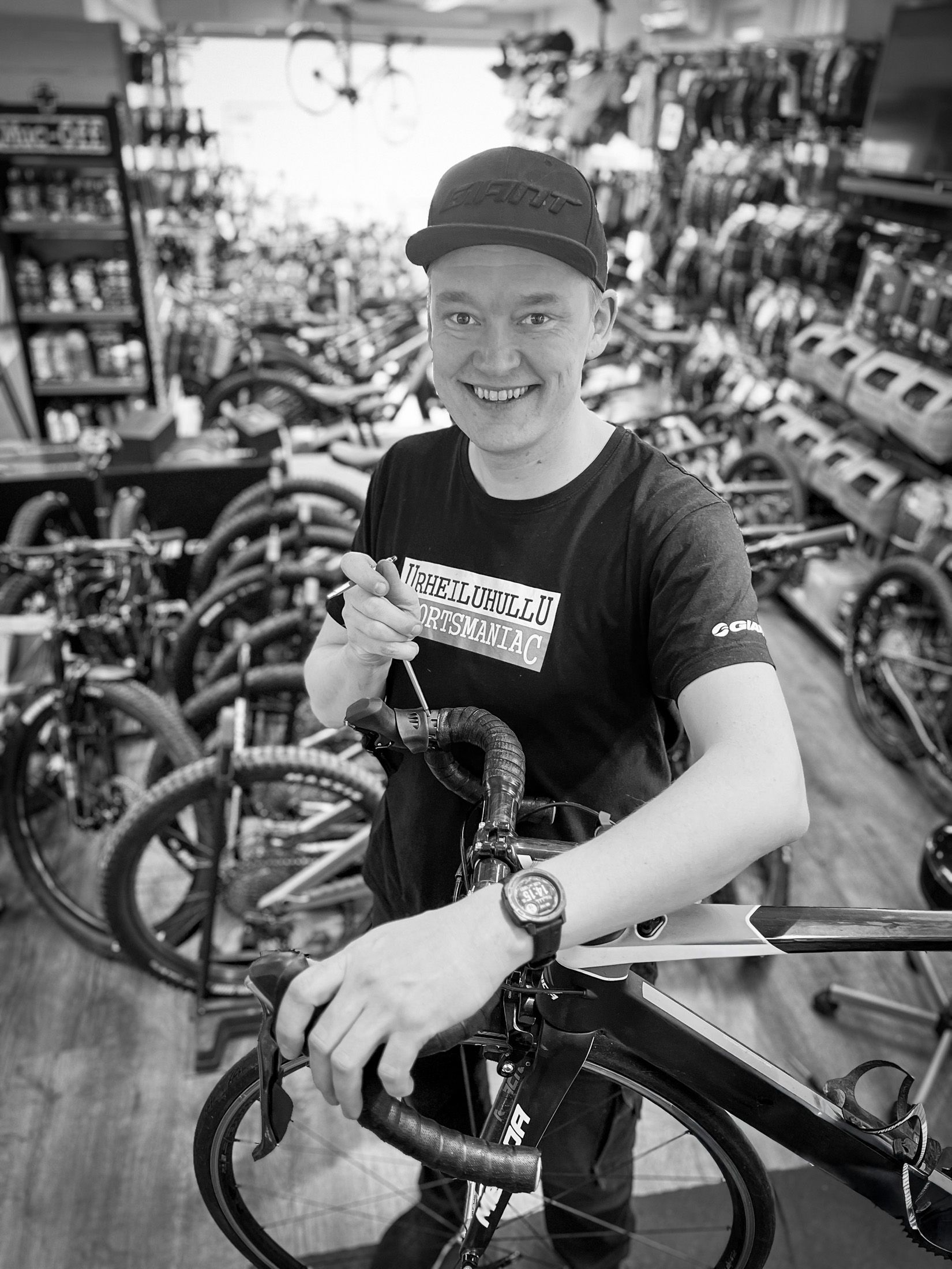 A man is standing next to a bicycle in a bicycle shop.