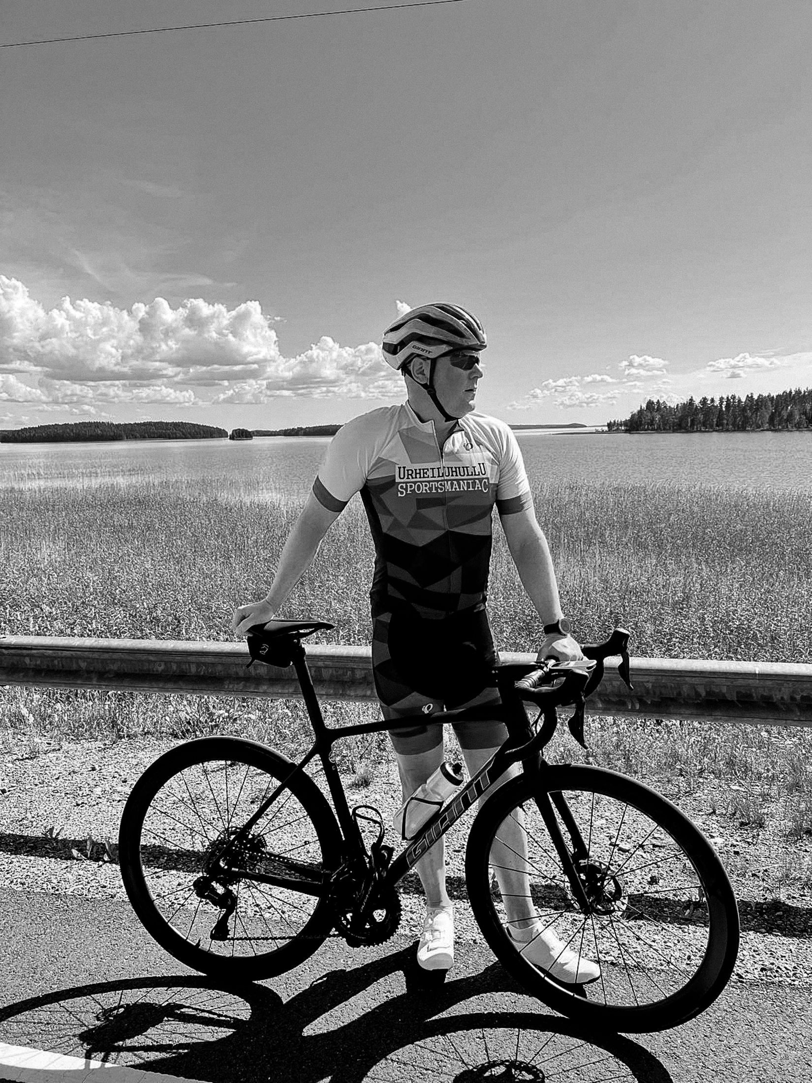 A man is standing next to a bicycle in a black and white photo.