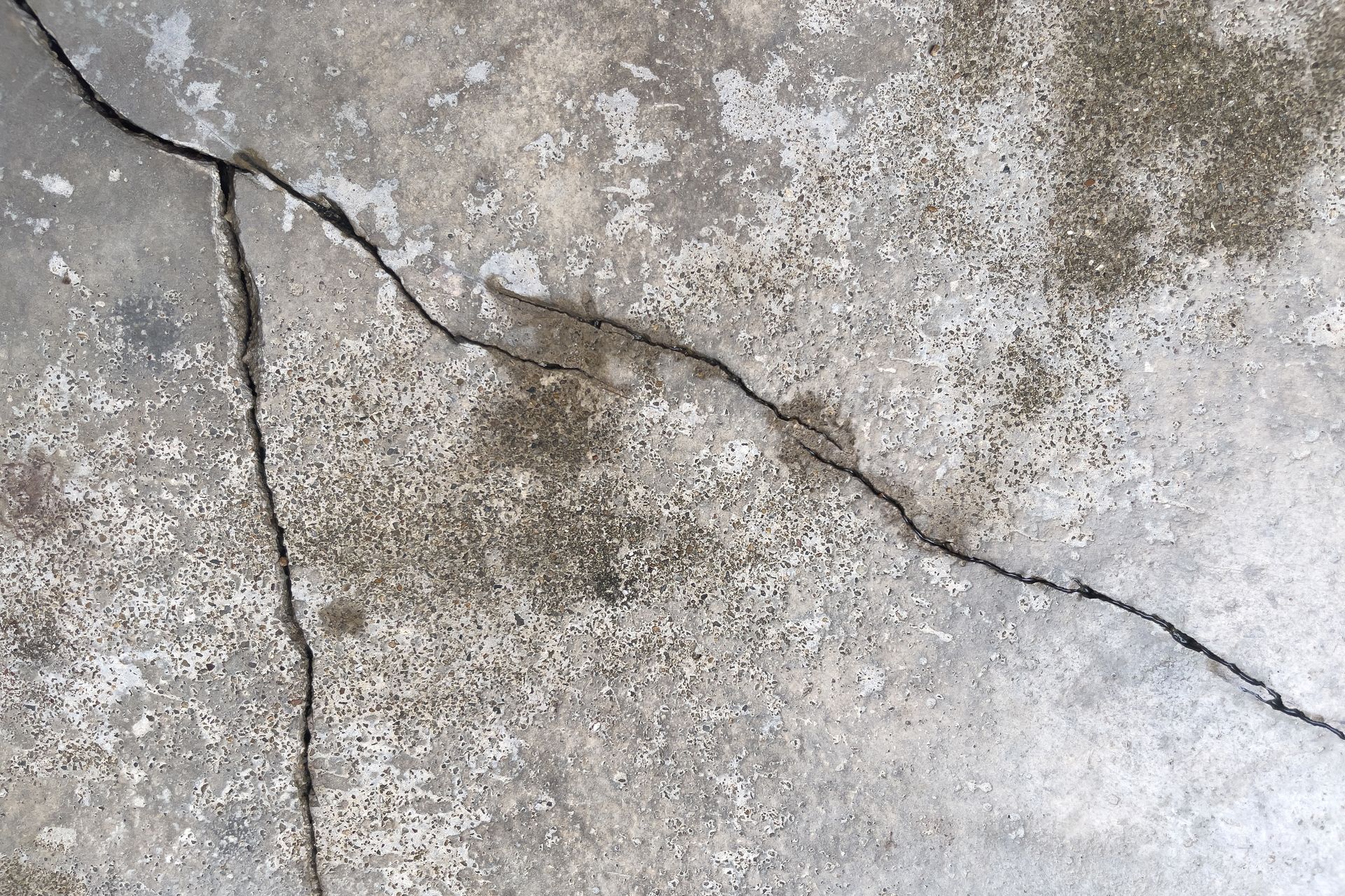 Cracked concrete surface with visible line running across, showing texture and discoloration
