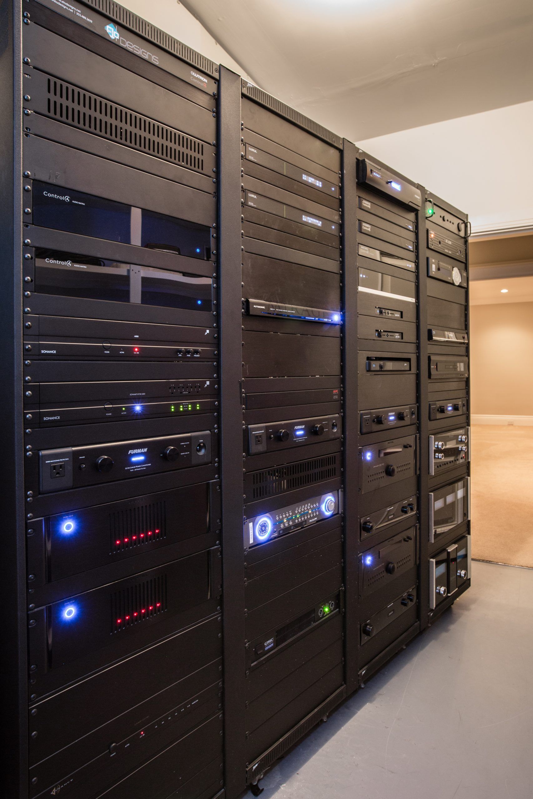 Black server racks filled with electronic equipment in a room.