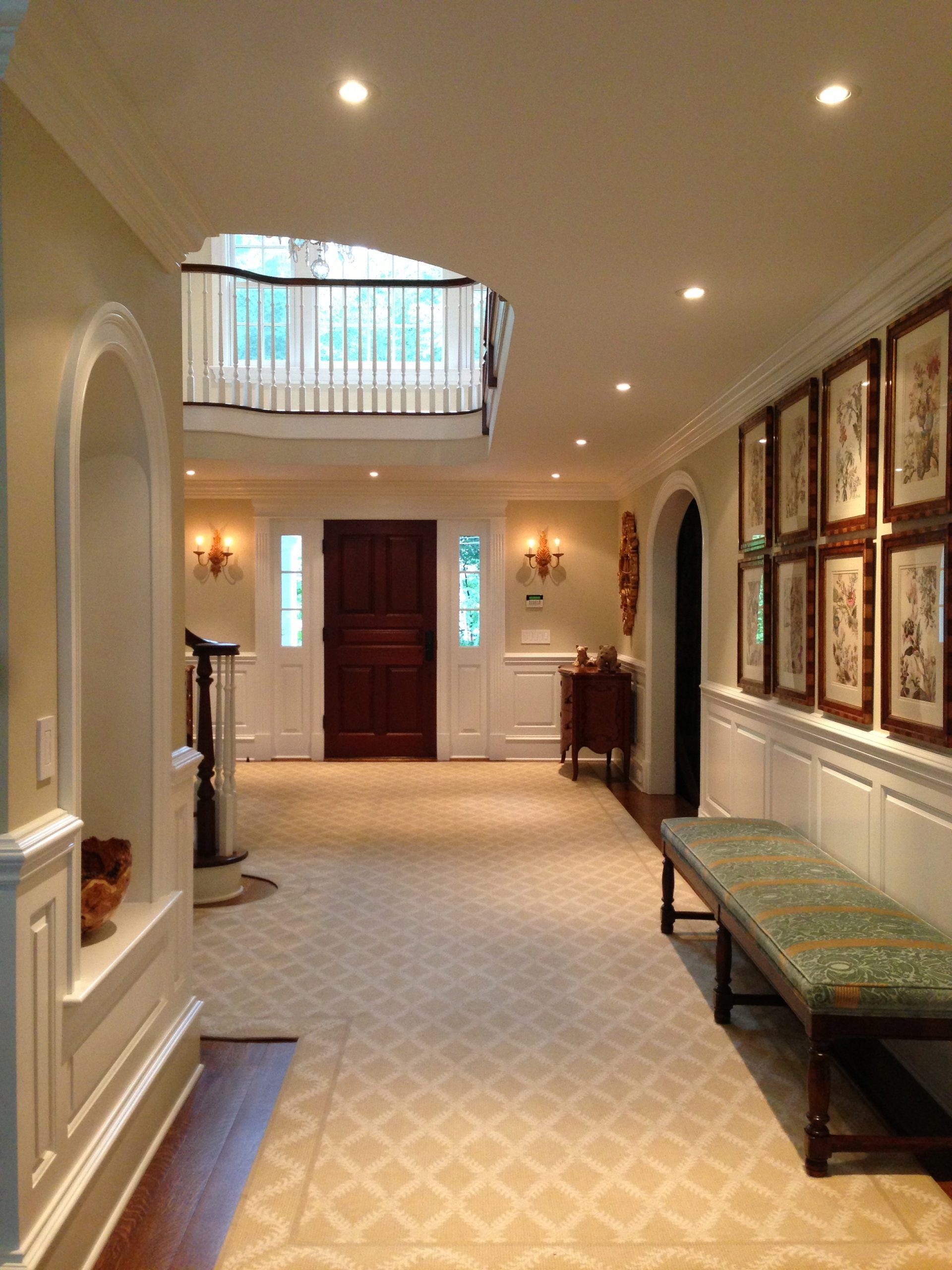 Hallway with patterned carpet, white trim, and framed artwork on wall.