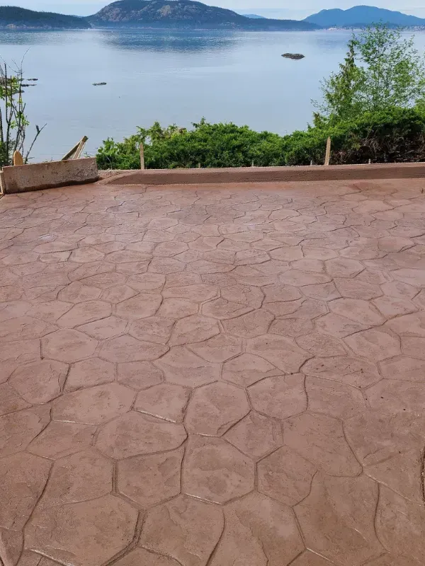 a concrete patio with a view of a lake and mountains in Bellingham Washington.