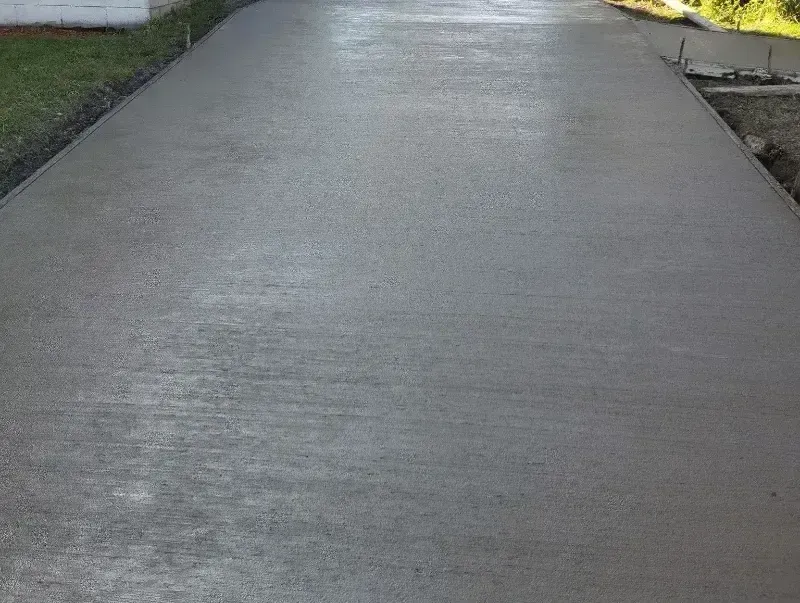 A concrete driveway is being built in front of a house.