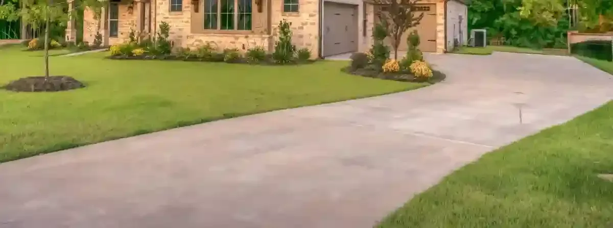 A driveway leading to a house with a lot of grass.