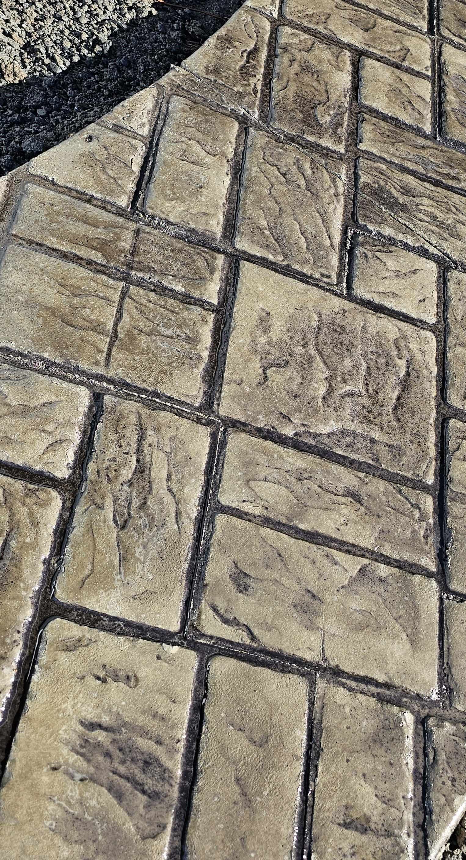 A close up of a brick floor with a black border.