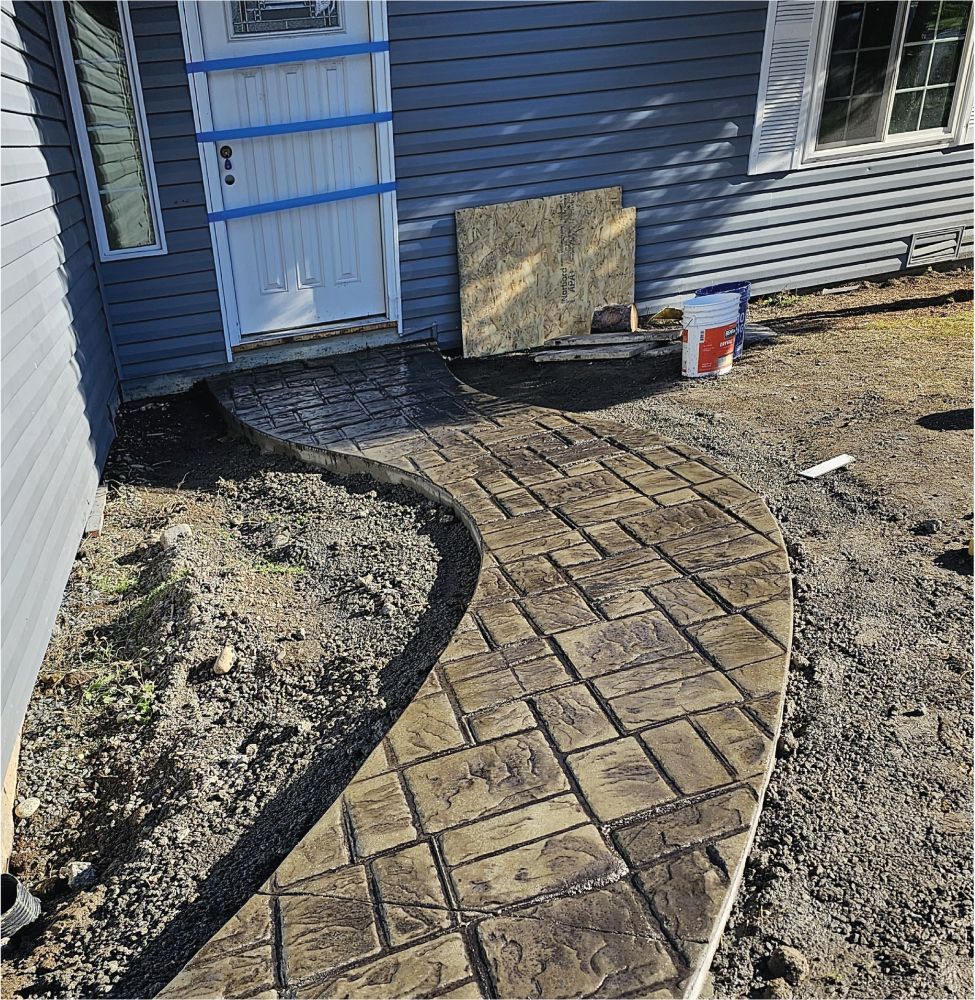 A concrete walkway is being built in front of a house.
