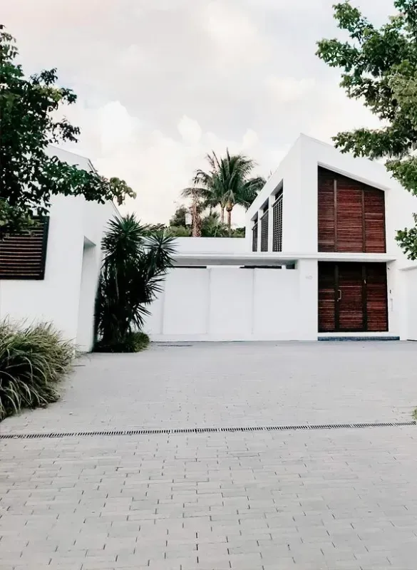 A white house with a large concrete driveway and palm trees in Bellingham WA