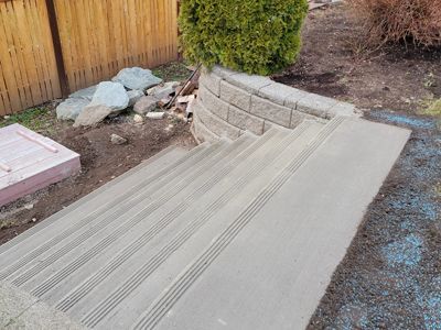 A set of concrete stairs leading up to a wooden fence.