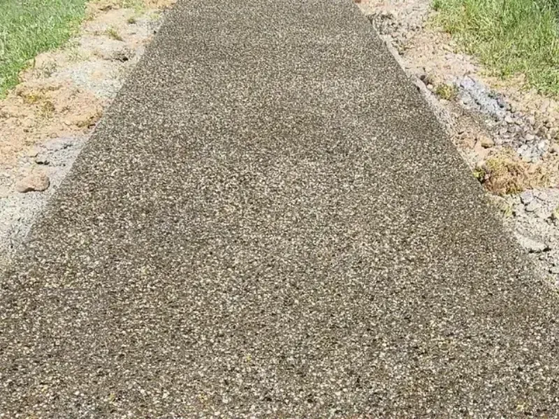 Gravel pathway between patches of grass and dirt.
