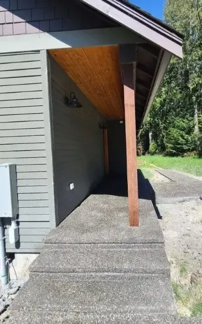 a concrete sand finish walkway and stairs leading to a house with a wooden porch in Bellingham Washington.