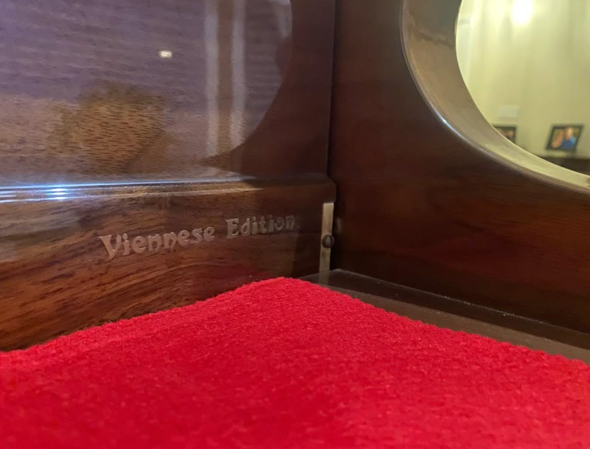 Polished wooden cabinet with red felt interior and engraved “Viennese Waltz” label