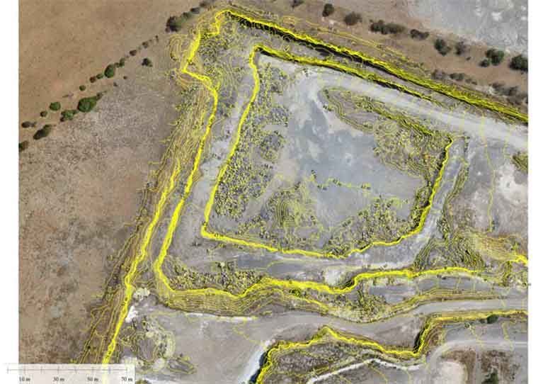 An aerial view of a dirt field with yellow lines.