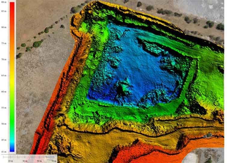 An aerial view of a colorful landscape with a lake in the middle.