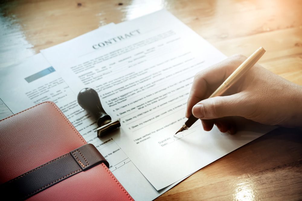 A Person Is Writing On A Piece Of Paper With A Pen — TGT Pty Ltd in Mareeba, QLD