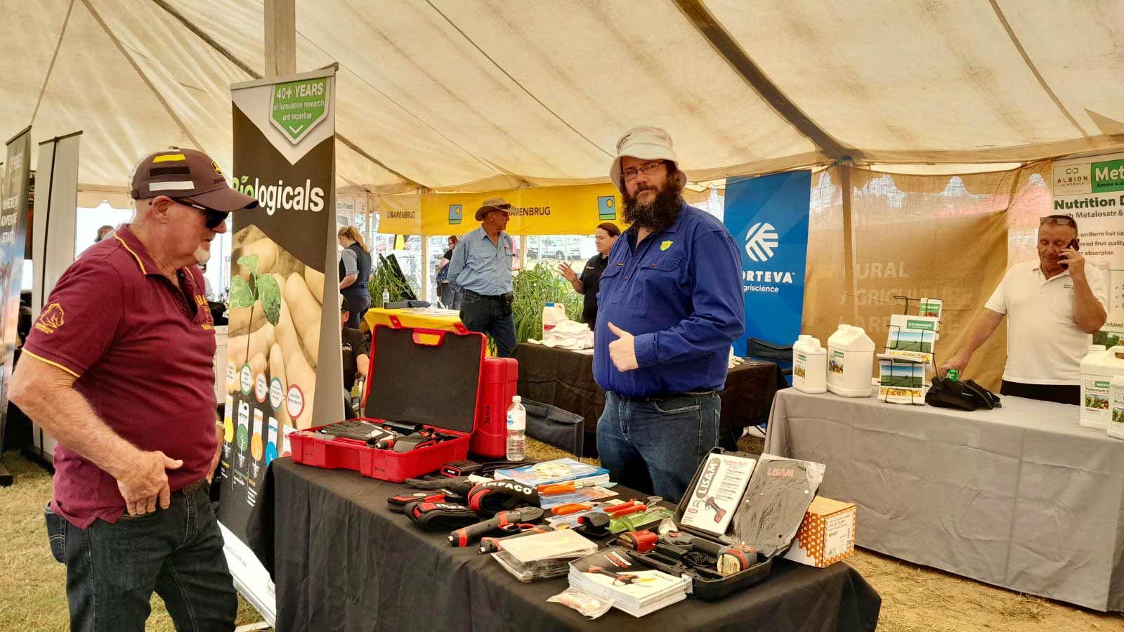 Two Men Are Standing In Front Of A Table With Tools On It — TGT Pty Ltd in Mareeba, QLD
